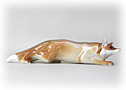 The sly fox  is a reddish brown fox figurine with a white underside and white-tipped tail. 